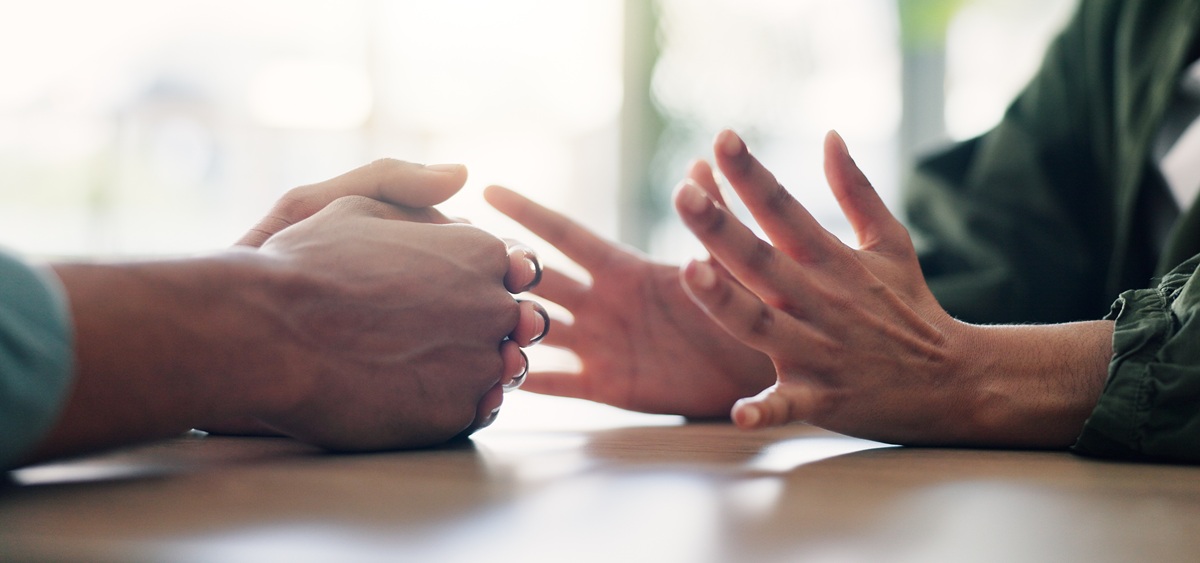 Couples in a parental union who want a court to settle issues related to their separation must go to the Unified Family Tribunal. A close-up of the hands of two people sitting at a table in an interior. Their gestures suggest verbal or emotional interaction.
