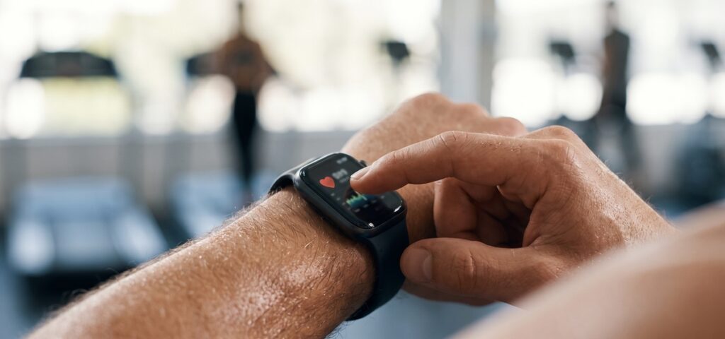 A person looking at their smartwatch, which shows personal information related to their health.