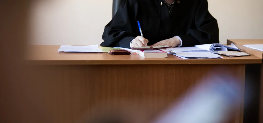 une juge consulte des documents dans une salle d’audience