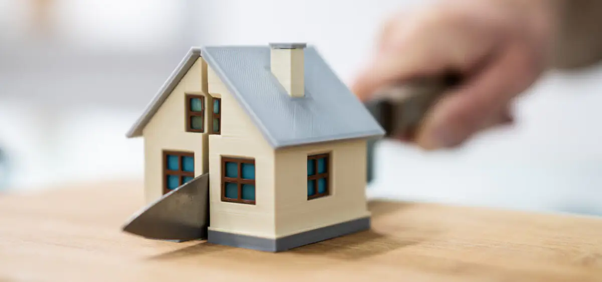 Une petite maison coupée en deux parties égales avec un couteau.