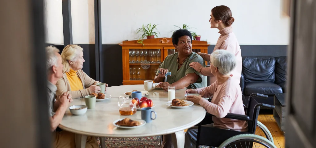 Un groupe de personnes âgées prenant le petit-déjeuner dans une résidence.