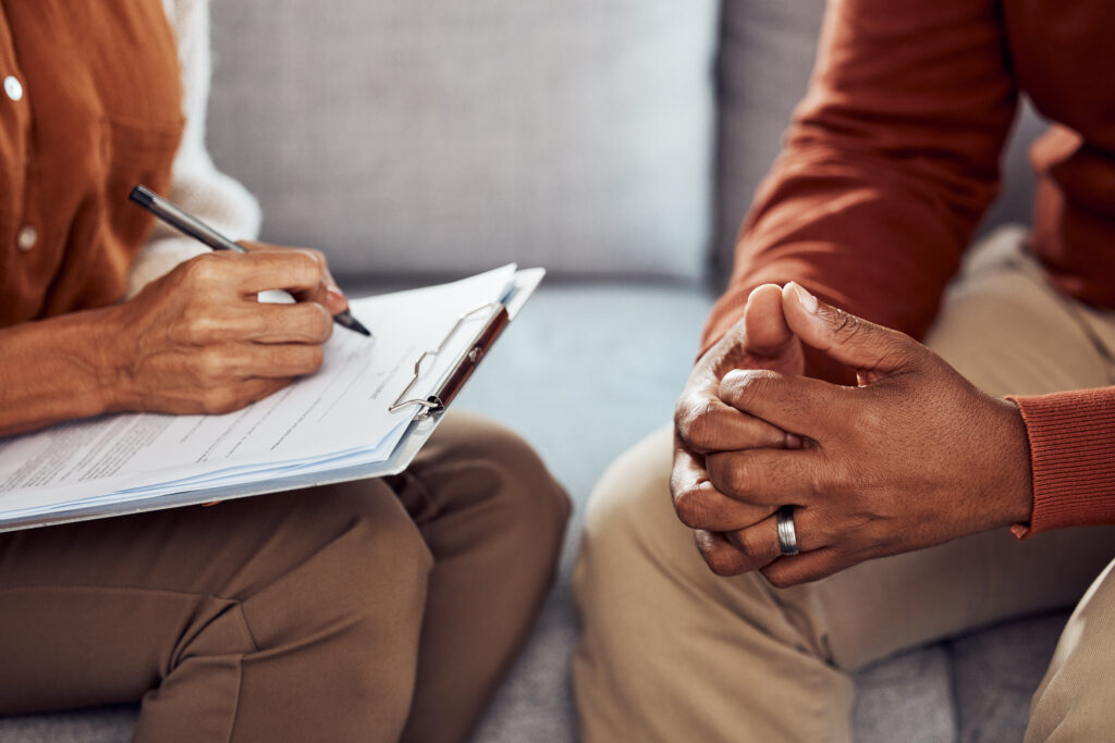 Two people sitting on a couch, signing documents