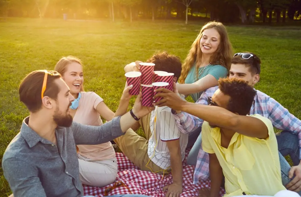 Peut-on boire de l’alcool dans les parcs? Un groupe d’amis trinque dans un parc.