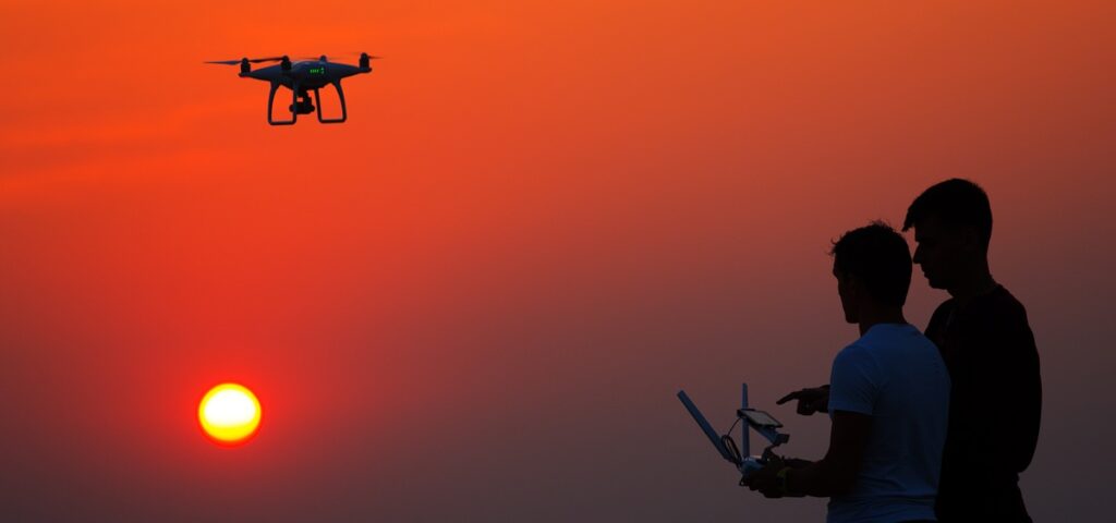 How to Fly a Drone Legally Person flying a drone outside during sunset.