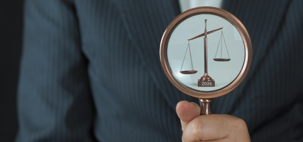 Legal changes to watch for this year Close up of a hand holding a magnifying glass, with a scale visible inside.